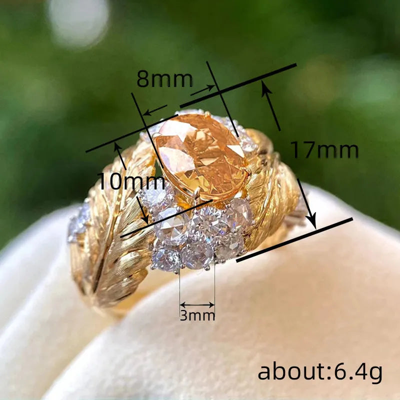 Gold-coloured copper women's ring with embossed feather design and inlaid yellow zircon stone.