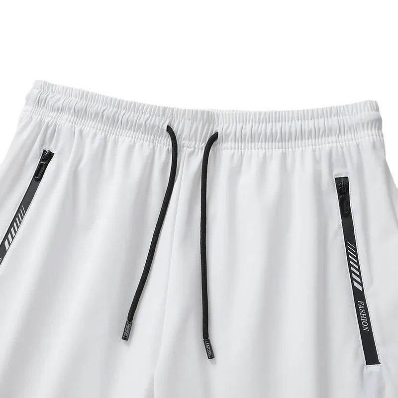 Men's black quick-drying nylon sports shorts with a loose fit and mid-thigh length on a grey background.