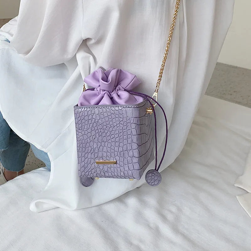 Small women's messenger bag with chain accents in six colour options including black green pink purple white yellow
