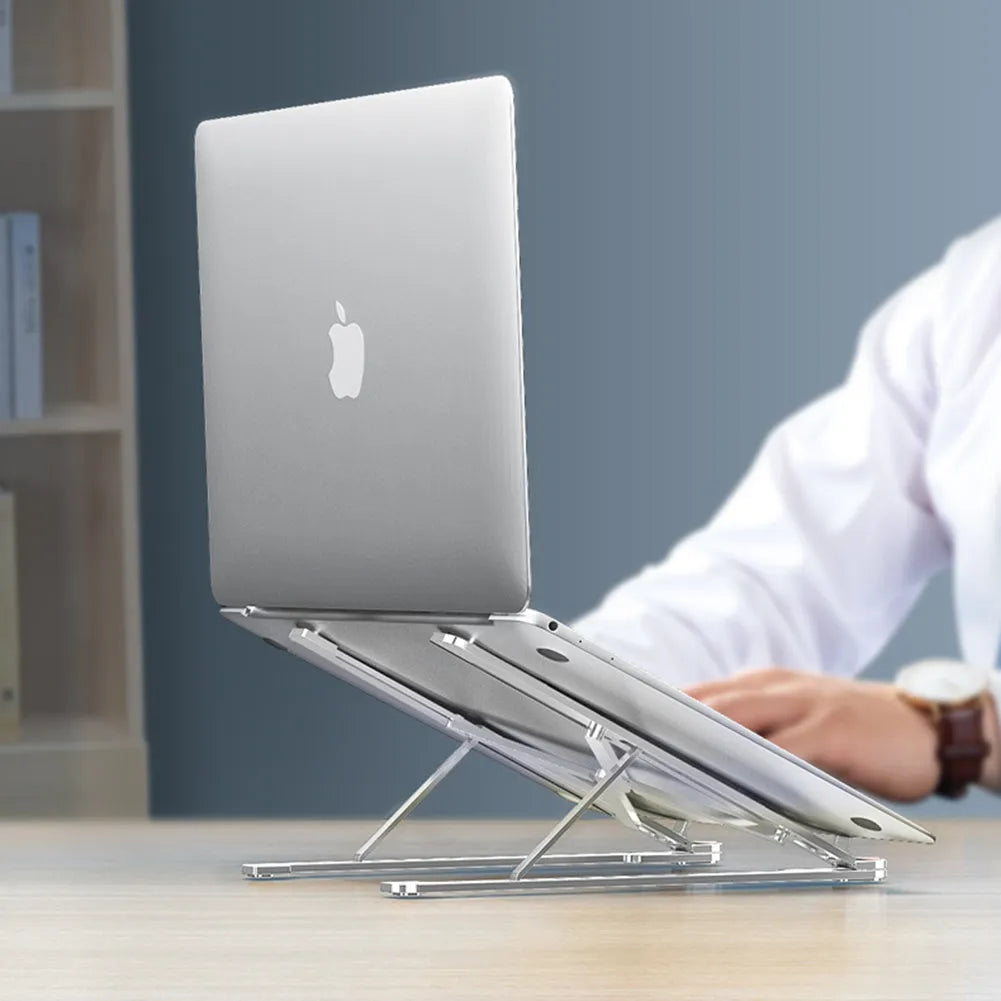 Portable aluminium laptop stand folded flat next to an open laptop showing its adjustable height.