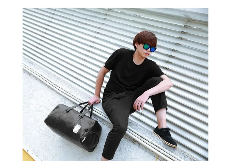 Black waterproof sports bag with separate side compartments for shoes, shown with diagonal carrying strap.