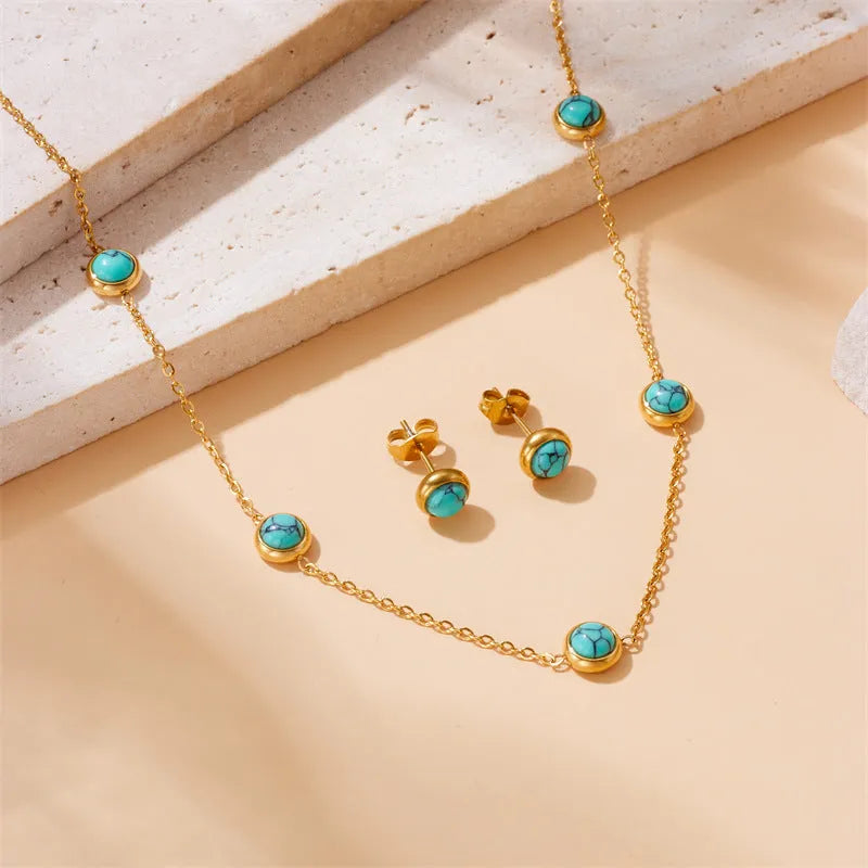 Round turquoise stainless steel earrings and necklace set on display