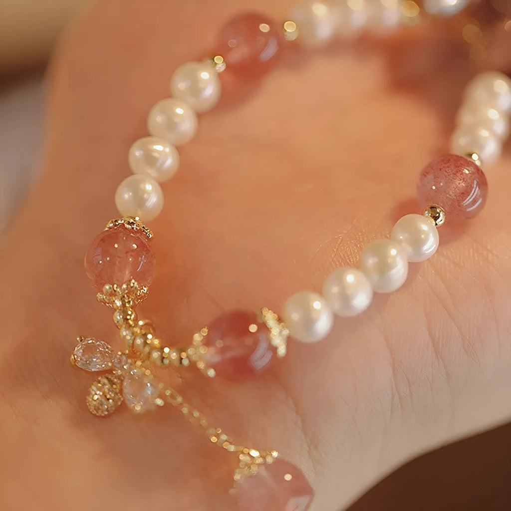 Women's hand-made strawberry quartz crystal bracelet with stringed pearls and bow detail