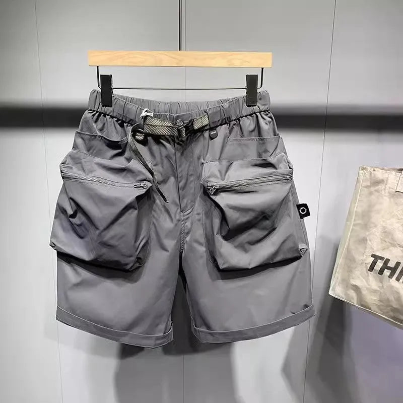 Men's solid black loose-fit work shorts with pockets, shown above the knee.