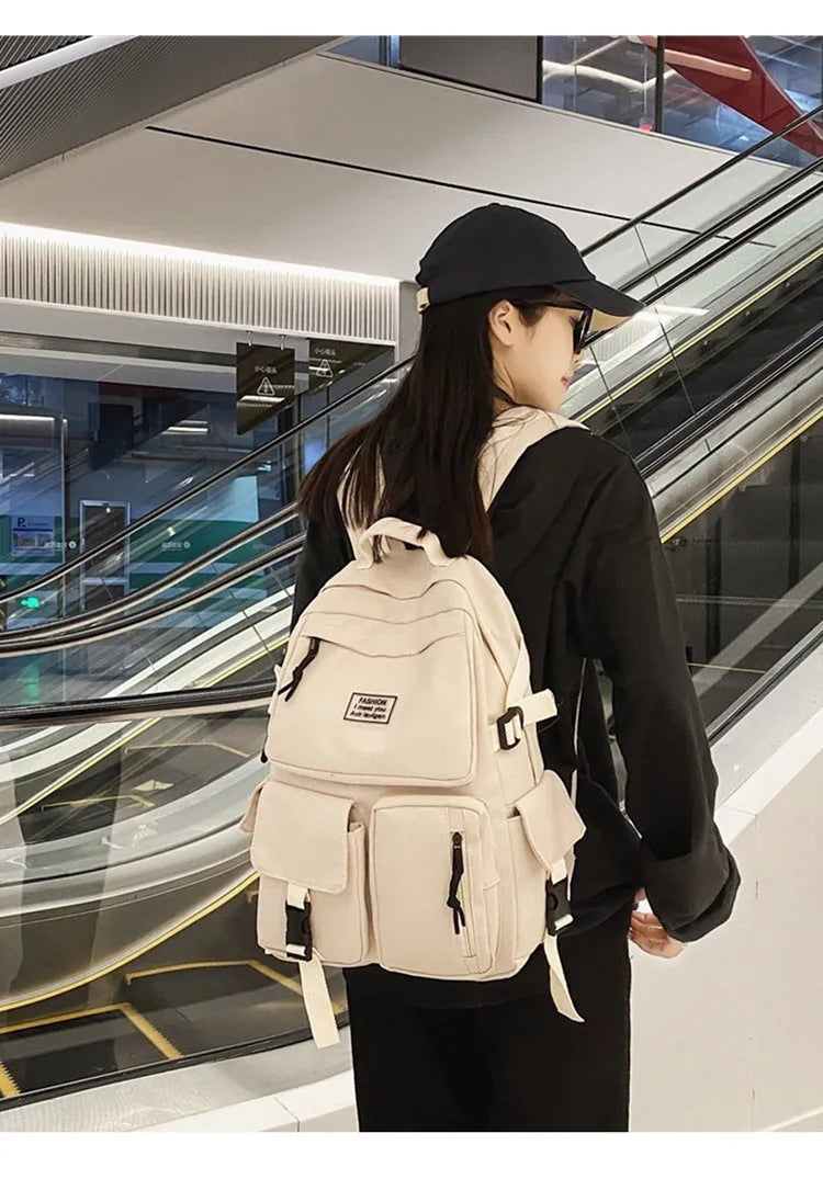 Black nylon student backpack showing front three-dimensional pocket and internal laptop compartment.