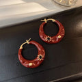 A pair of retro alloy ear studs with a dripping oil finish and black rhinestone detail.