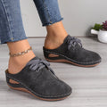 Women's lace-up suede wedge slippers with a hollow-out design, shown in a light colour on a foot.