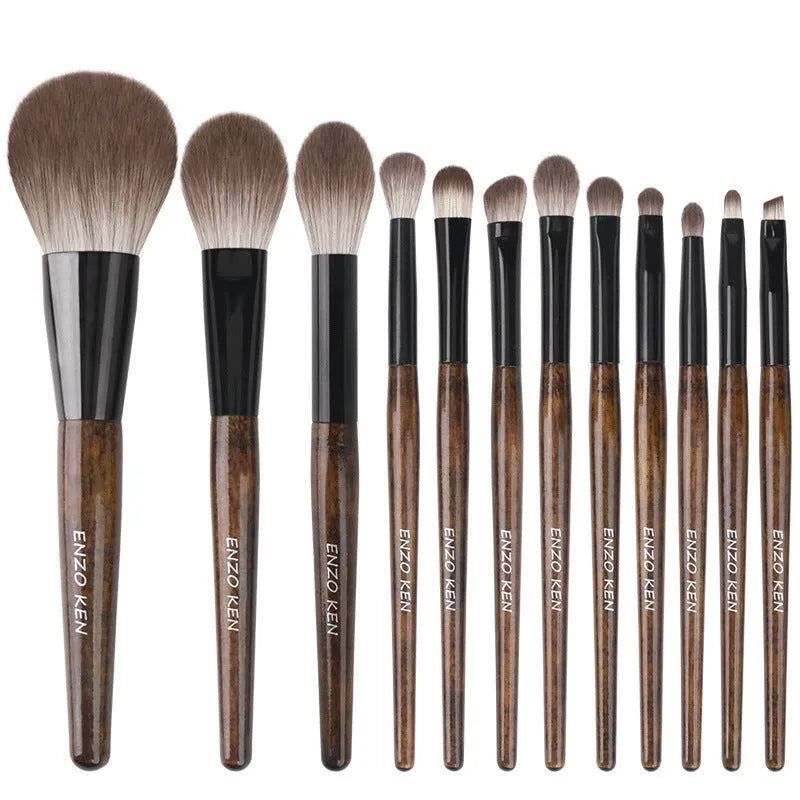 12-piece makeup brush set with wooden handles and a grey PU storage pouch.