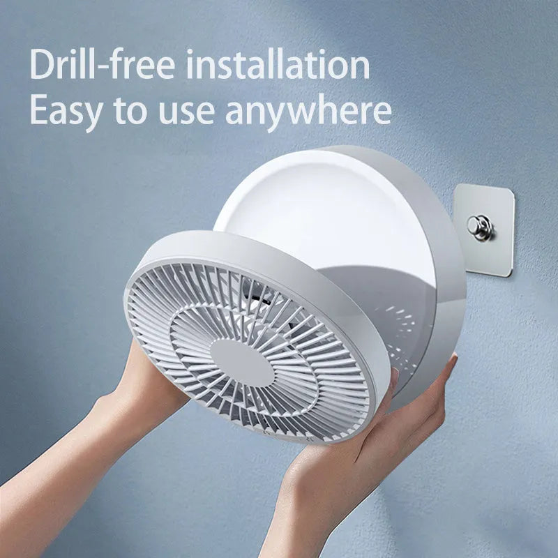 White portable USB folding desk fan with remote control and warm night light on a table.