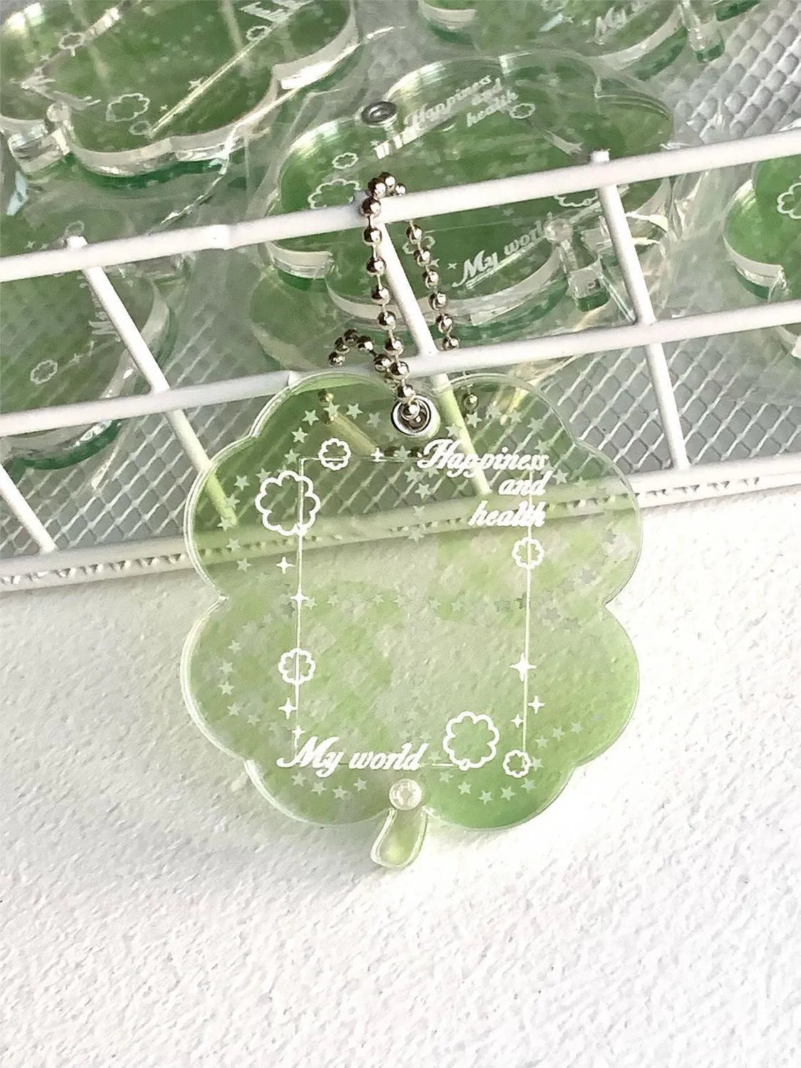 Acrylic four-leaf clover pendant keychain for phones in blue, green, and mint colour options.