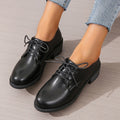 Black women's low top work shoes with a short chunky heel and pointed toe.