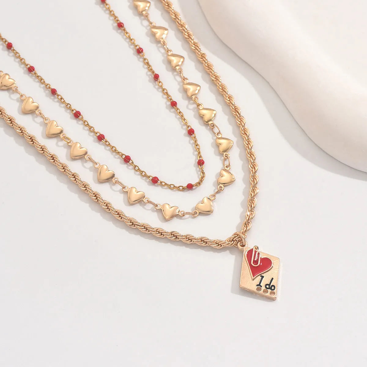 Silver adjustable three-layer clavicle chain necklace with a geometric love pendant.
