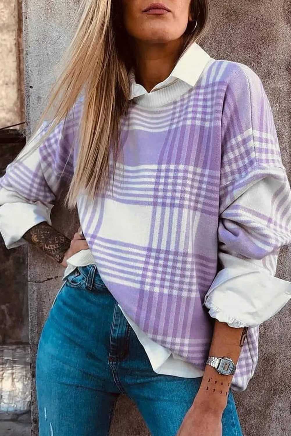 Loose lilac plaid print sweater with long sleeves and ribbed trim on a hanger.