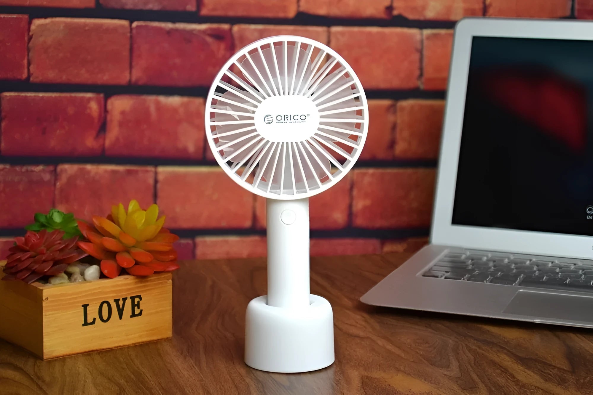 White ORICO FH1 USB rechargeable portable fan with fine-line texture on desk.