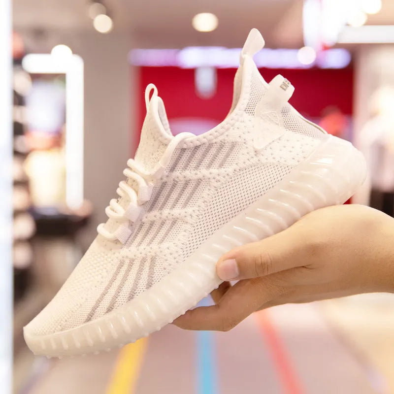 Men's white low-cut breathable sports shoes with a round toe and flat platform heel on a plain background.