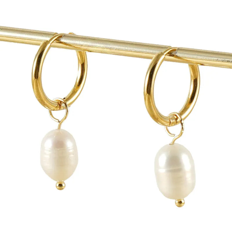 A pair of gold-coloured geometric stud earrings with a single pearl accent on each.