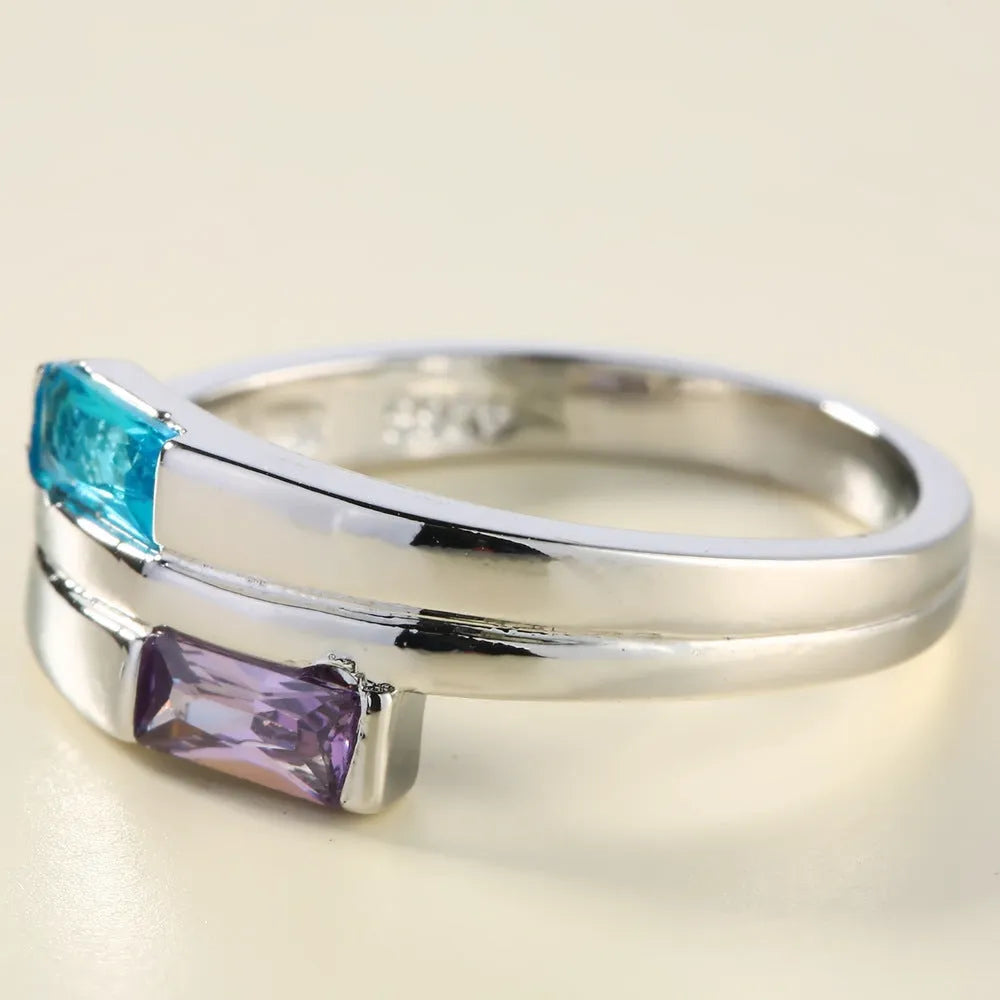 Silver-coloured copper ring with a central inlaid zircon stone, shown on a finger.
