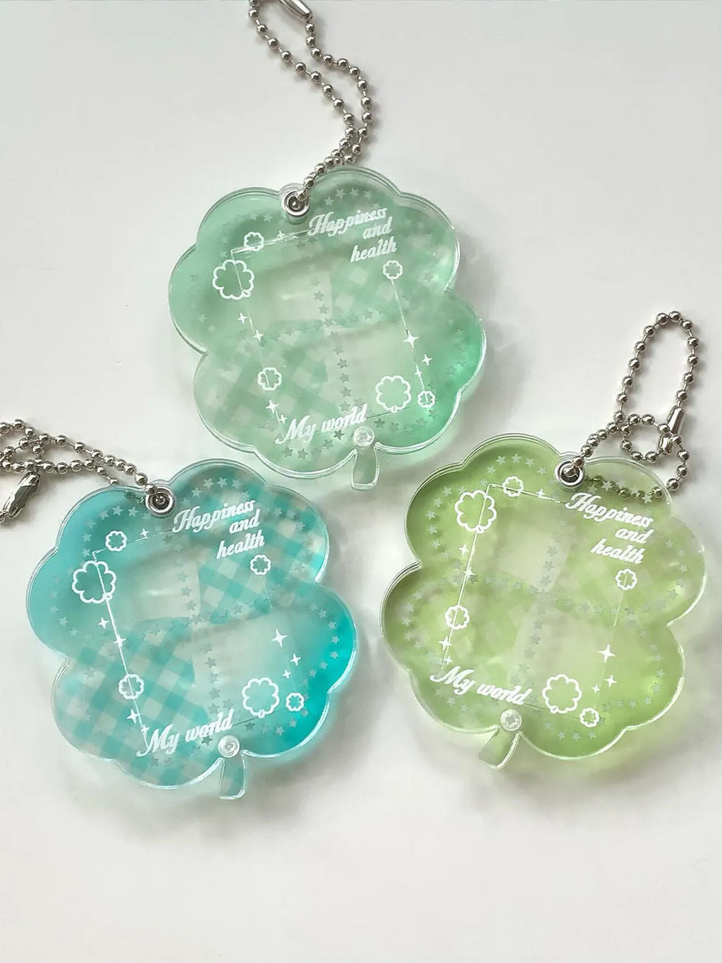 Acrylic four-leaf clover pendant keychain for phones in blue, green, and mint colour options.