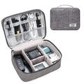 Black waterproof electronics travel organizer case open, showing mesh pockets, elastic loops and removable padded dividers.