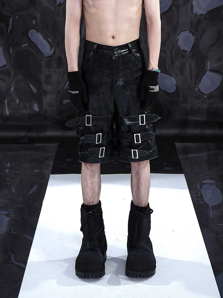 Black men's PU leather cropped shorts on a model, showing medium low waist and casual fit.
