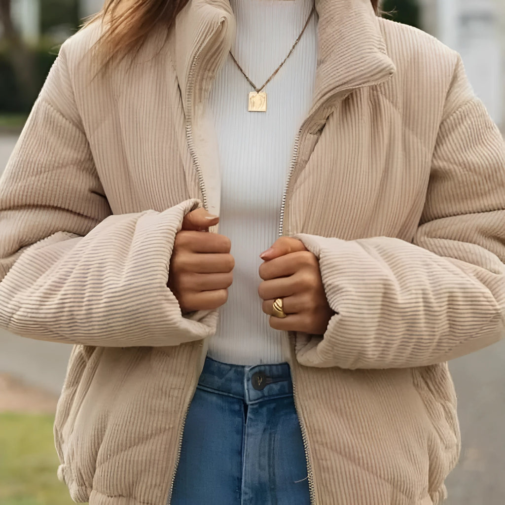 Women's apricot coloured corduroy jacket with a stand collar and front zipper on a hanger.