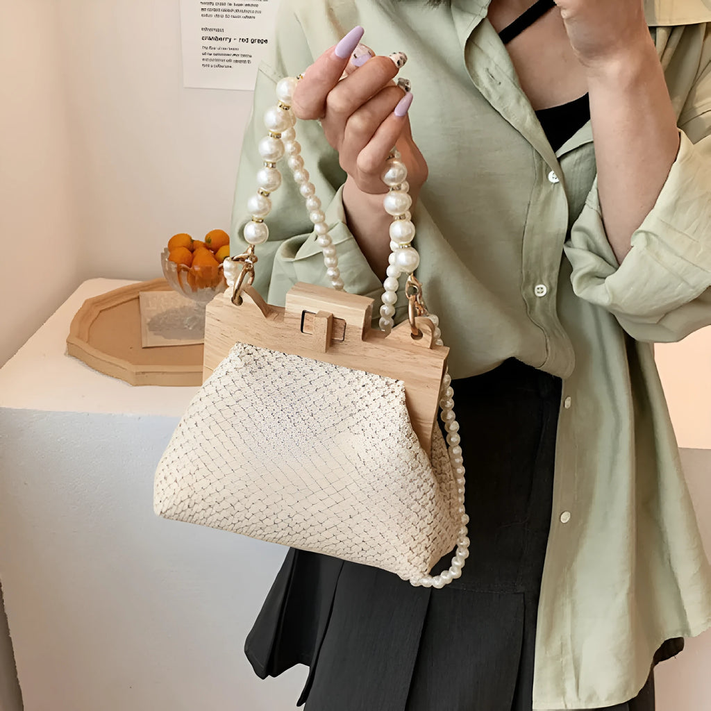 Women's woven straw shoulder bag with pearl chain details showing interior organisation compartments