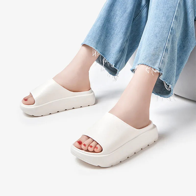 Women's beige fish mouth slippers with a thick sole on a wooden floor.
