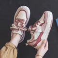 Women's pink low-top sneakers with imitation leather upper and rubber sole for hidden height increase.