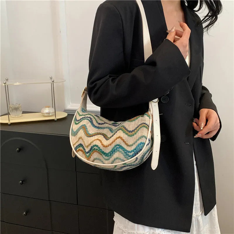 Women's woven straw crossbody bag with adjustable strap and interior organisation compartments