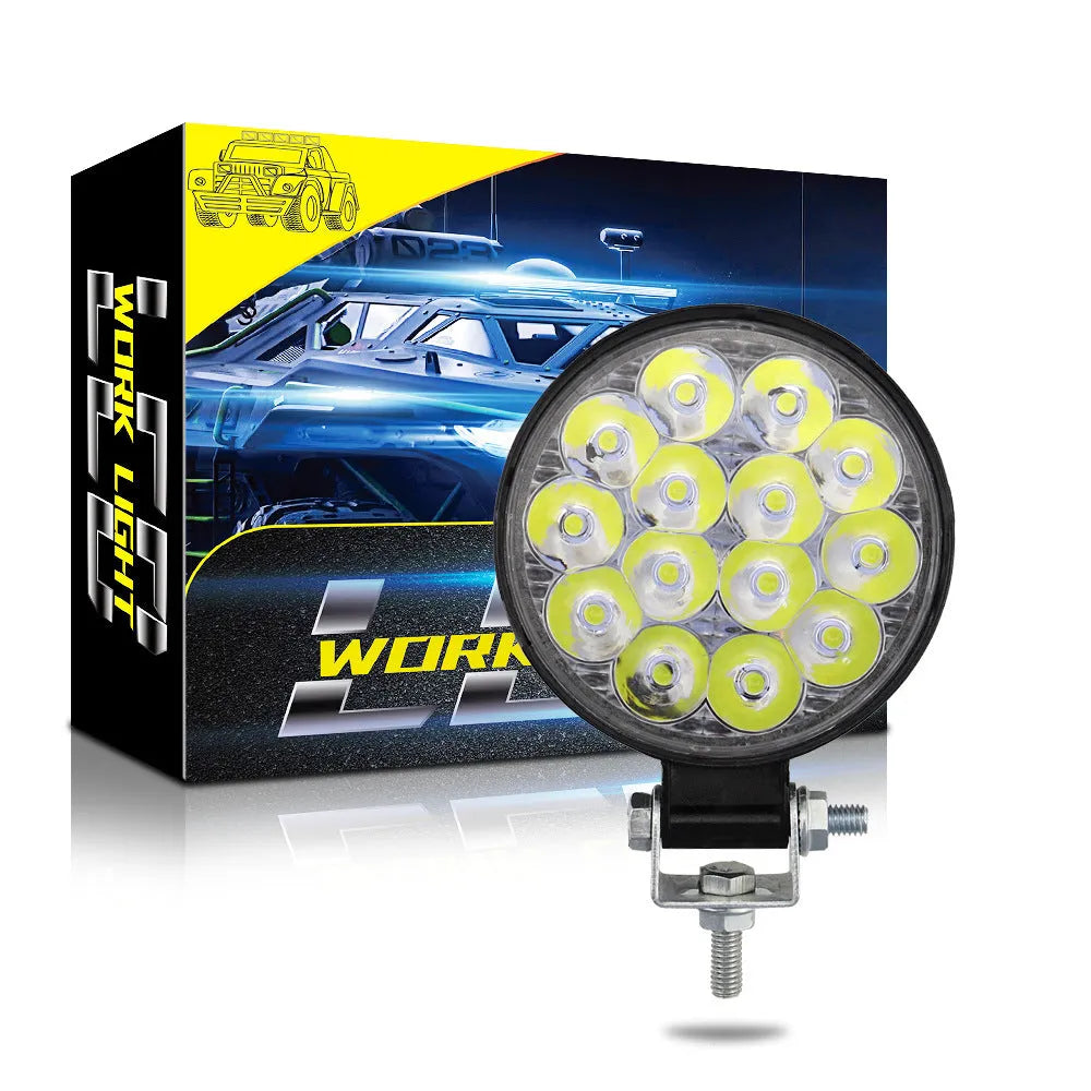 White aluminium LED work light with a round design, suitable for mounting on a vehicle.