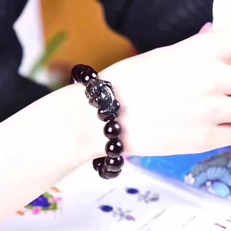 Natural ice colour Eye Obsidian crystal beaded bracelet on a wrist, showing clear spherical beads.
