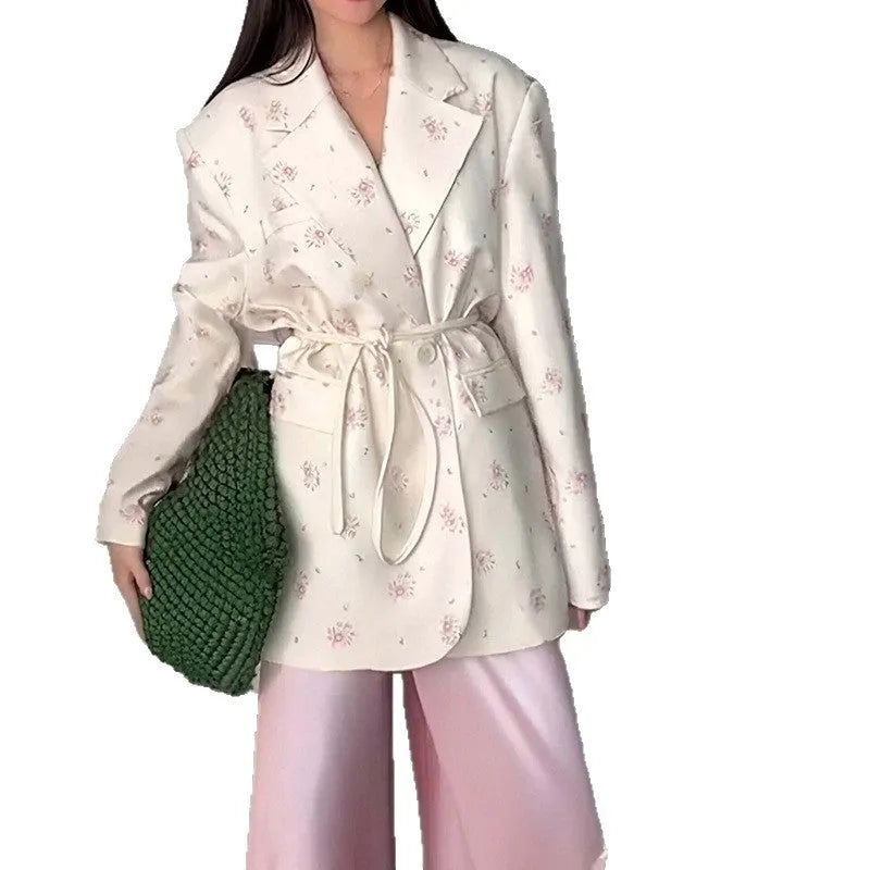 Women's floral print suit jacket with lace-up waist closure on a hanger.