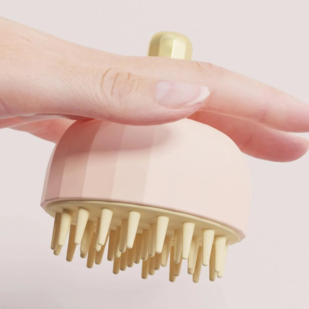 Green pet bath massage brush with drain holes, shown next to a bottle of shampoo for scale.