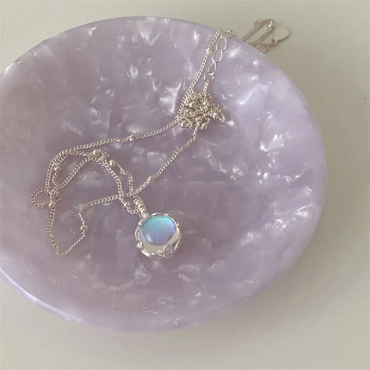 Silver geometric ornamental stone pendant on a curb chain necklace for women.