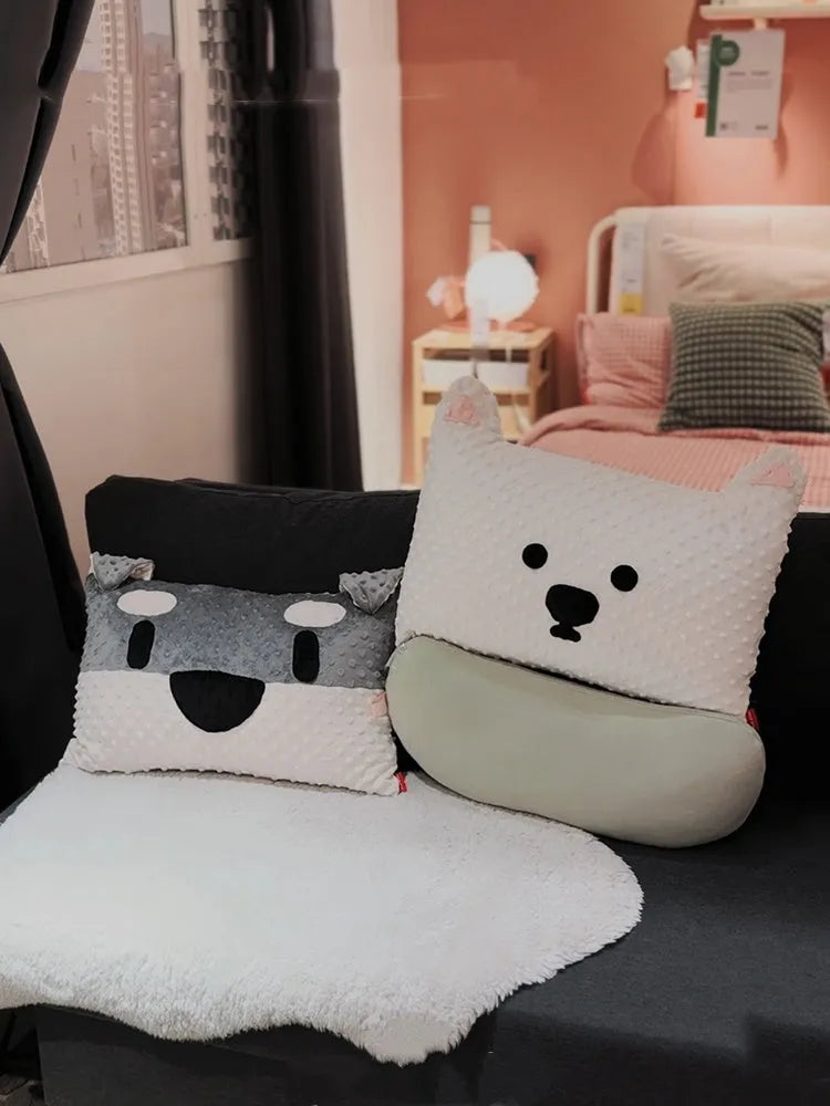 Grey schnauzer and white West Highland puppy decorative throw pillows on a sofa.