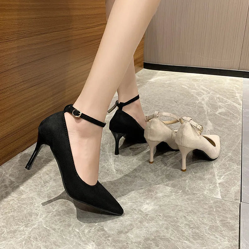 Women's black stiletto pump shoes with a buckle decoration on the upper