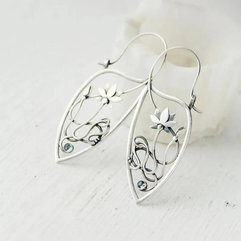 Silver rhinestone earrings with geometric lotus vine design on alloy base