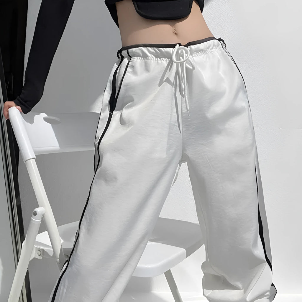 Women's loose straight-leg trousers with contrast ribbon detail in navy blue.