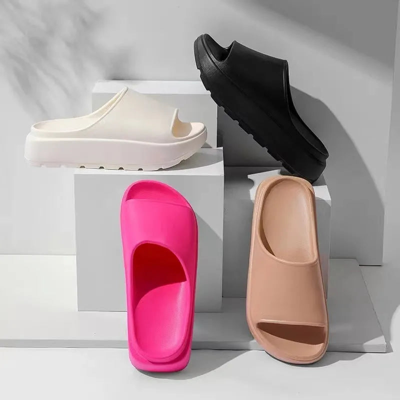 Women's beige fish mouth slippers with a thick sole on a wooden floor.