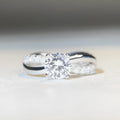 Geometric cross pattern silver ring with 1 karat moissanite stone in twisted arm setting