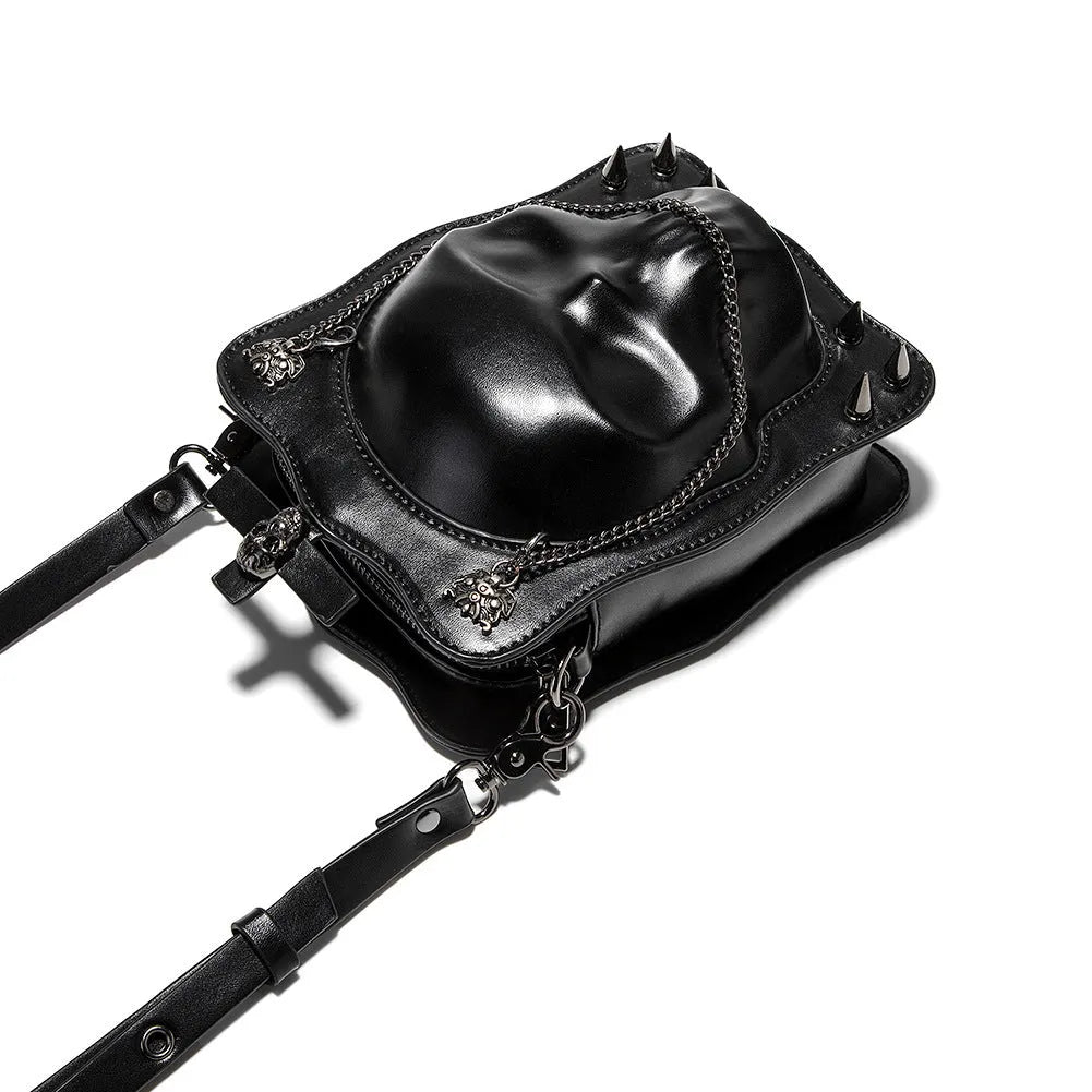 Black mini skull shoulder bag with 3D embossed design, chain strap, and vertical square shape for Gothic fashion.