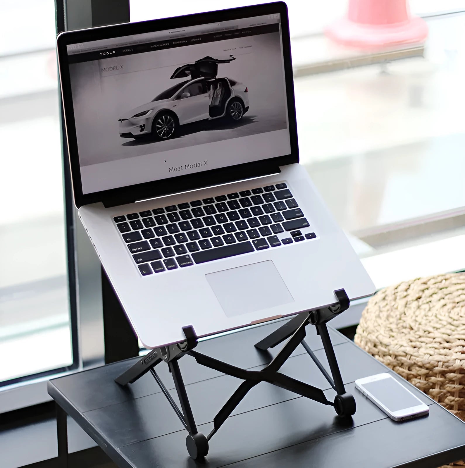 Black folding portable laptop stand made from reinforced nylon, shown in open and closed positions.