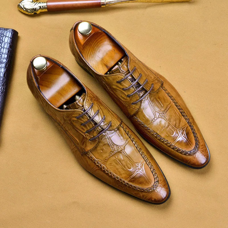 Men's black leather formal shoes with alligator pattern texture and a horse bit buckle detail.