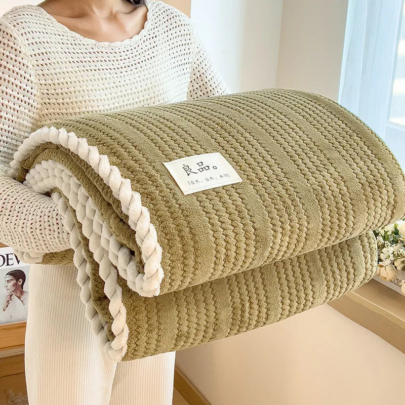 Solid colour jacquard milk velvet blanket in cream white, folded on a sofa, showing textured weave pattern