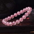 Women's strawberry quartz bracelet with polished beads on elastic string, shown in 6mm, 8mm, and 10mm size options.