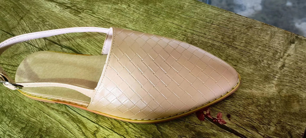 A pair of black baotou flat sandals with a buckle fastening and pointed toe on a plain background.