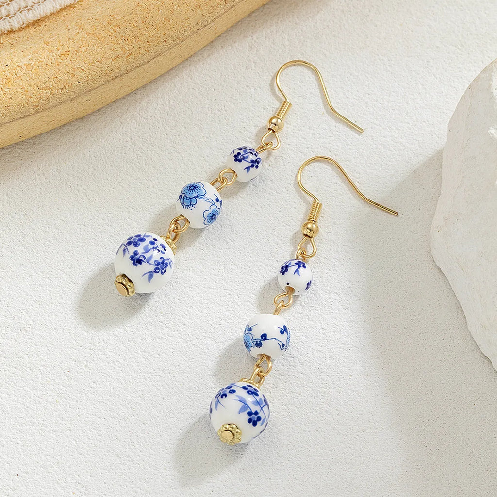 Long retro earrings with blue and white ceramic beads and geometric alloy parts.