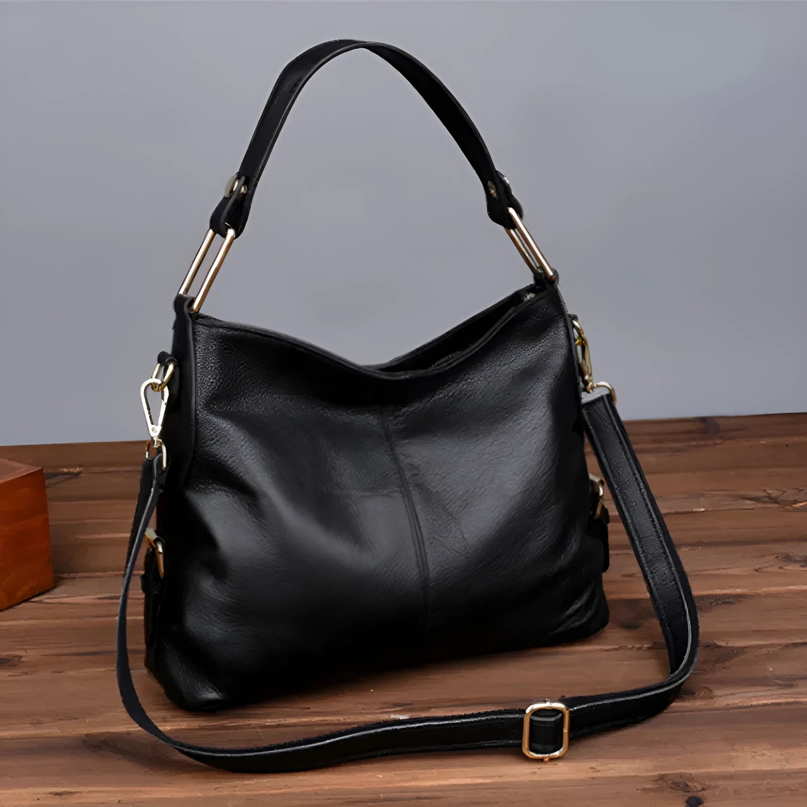Genuine leather vertical square crossbody bag in black colour with visible stitching and multiple compartments.