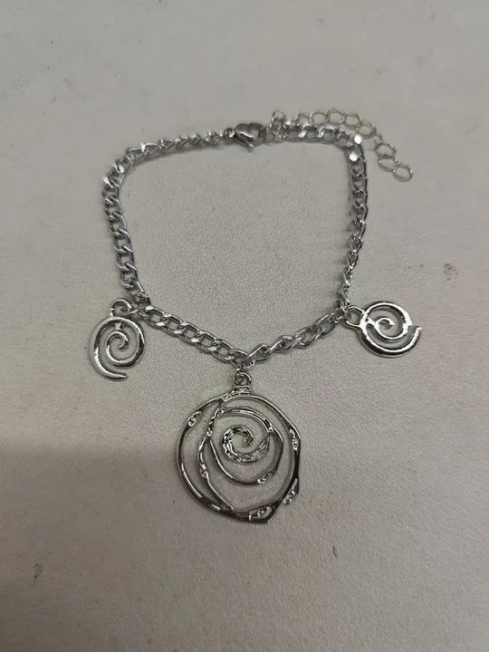 Gold spiral donut geometric jewellery set with adjustable necklace, matching bracelet, and earrings on a white background.
