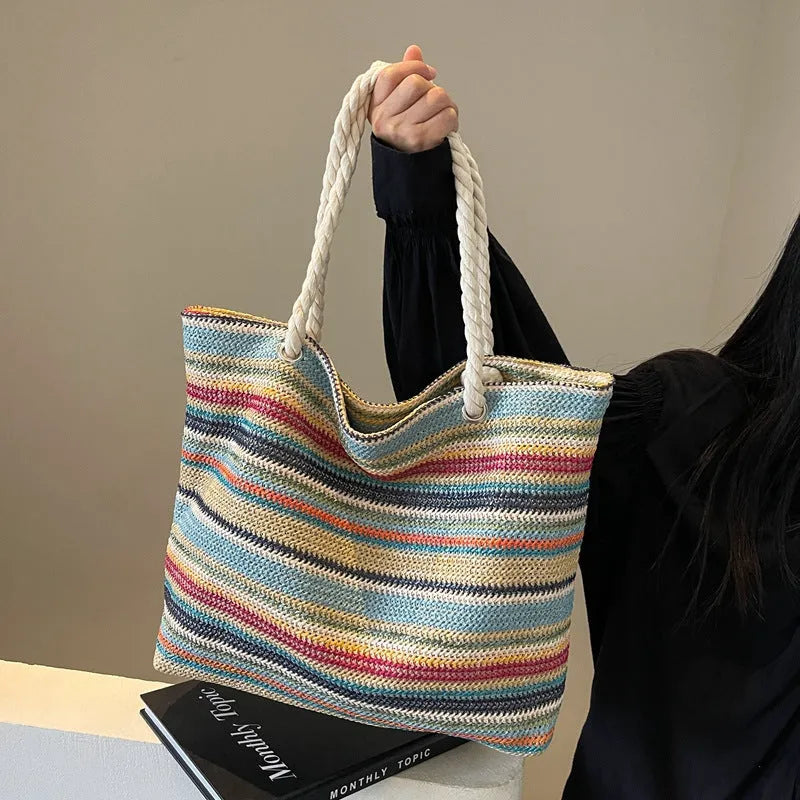 Blue woven nylon shoulder bag with an adjustable strap shown on a model.